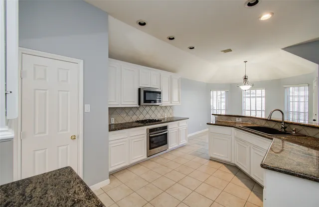 a kitchen with granite countertop a sink and cabinets