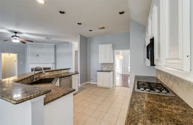 a kitchen with stainless steel appliances kitchen island granite countertop a sink stove and cabinets