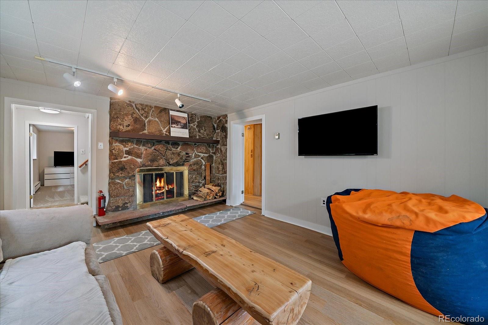 307 Snyder Mountain Road Evergreen, CO 80439 - Photo 28 of 41 a living room with furniture flat screen tv and fireplace