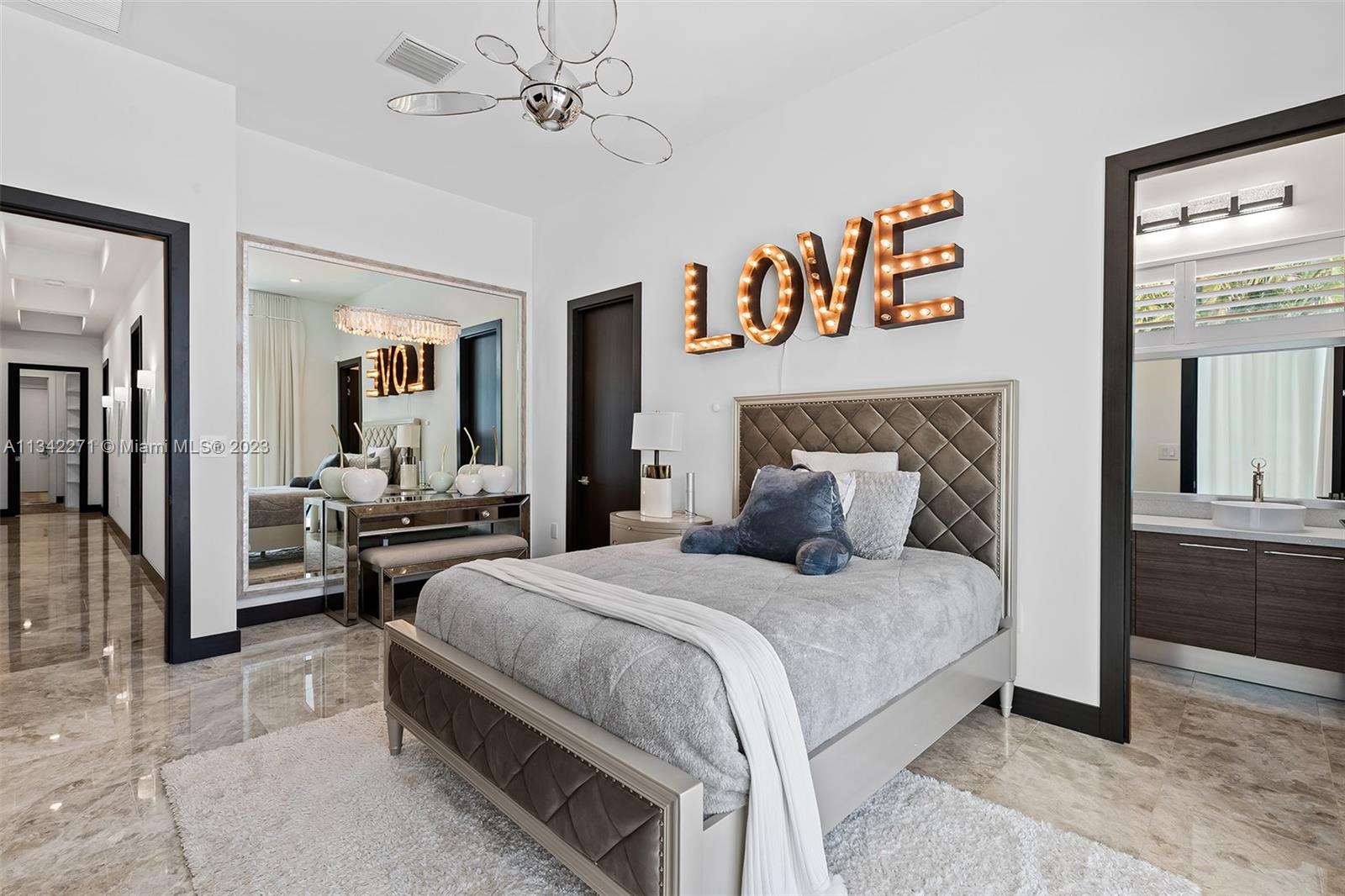 2610 Oak Park Drive Davie, FL 33325 - Photo 26 of 60 a bedroom with a bed and a chandelier