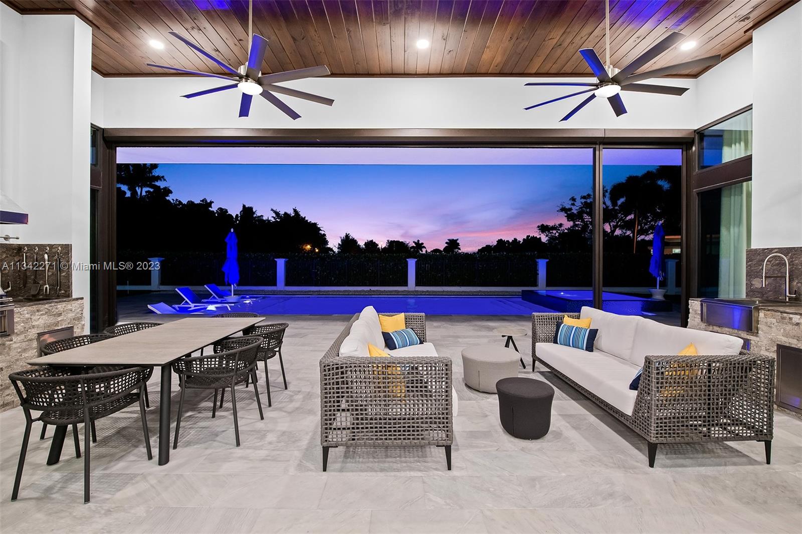 2610 Oak Park Drive Davie, FL 33325 - Photo 53 of 60 a view of a patio with a dining table and chairs with a barbeque grill and a floor to ceiling window