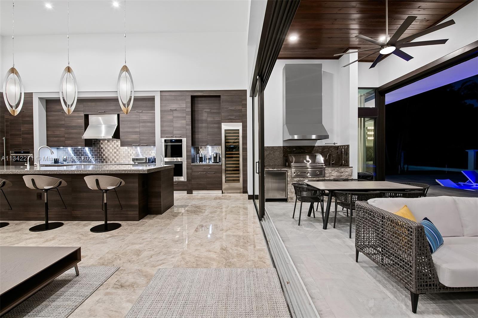 2610 Oak Park Drive Davie, FL 33325 - Photo 54 of 60 a living room with stainless steel appliances kitchen island granite countertop a stove a sink dishwasher and a flat screen tv