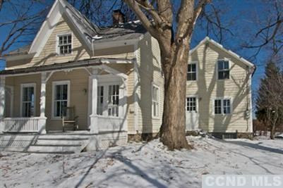 a view of a white house with large windows and a tree