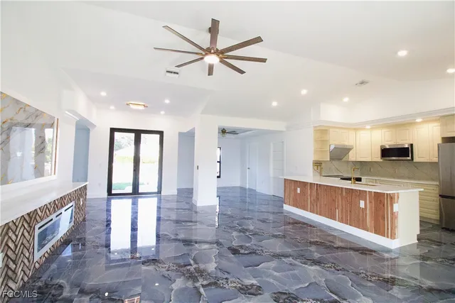a large kitchen with stainless steel appliances a large counter top and a sink