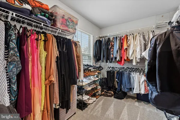 a view of walk in closet with clothes