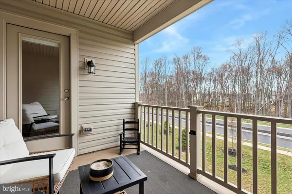 a view of a balcony with furniture and a gate