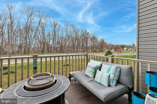 a balcony with wooden floor and outdoor seating