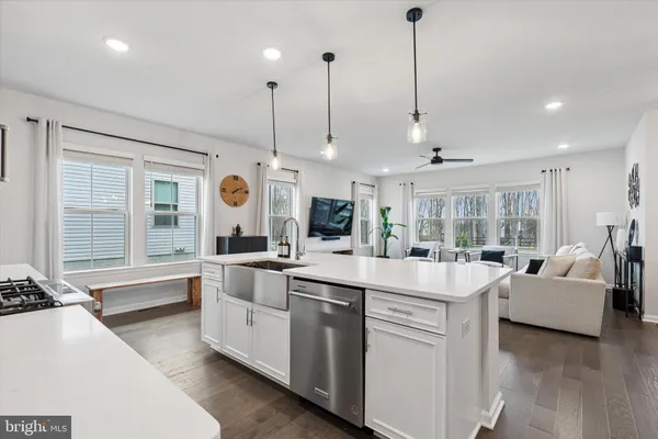 a large kitchen with kitchen island a large counter top space a sink stainless steel appliances and cabinets