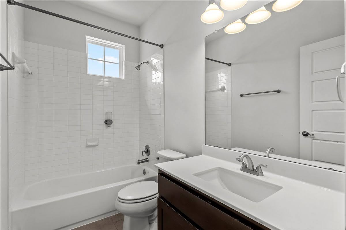 4108 Bison Bend, Unit FOR RENT Cedar Park, TX 78613 - Photo 29 of 36 Full Bathroom 3. A well-appointed bathroom features a bathtub, toilet, and vanity with a sink, all in a neutral color palette.