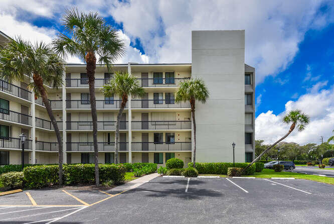 1605 Highway 1, Unit M1101 Jupiter, FL 33477 - Photo 4 of 27 a front view of building with yard street and trees