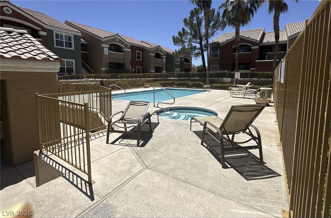 8101 West Flamingo Road, Unit 2131 Las Vegas, NV 89147 - Photo 9 of 13 An inviting community pool and spa area await residents, surrounded by well-maintained buildings.