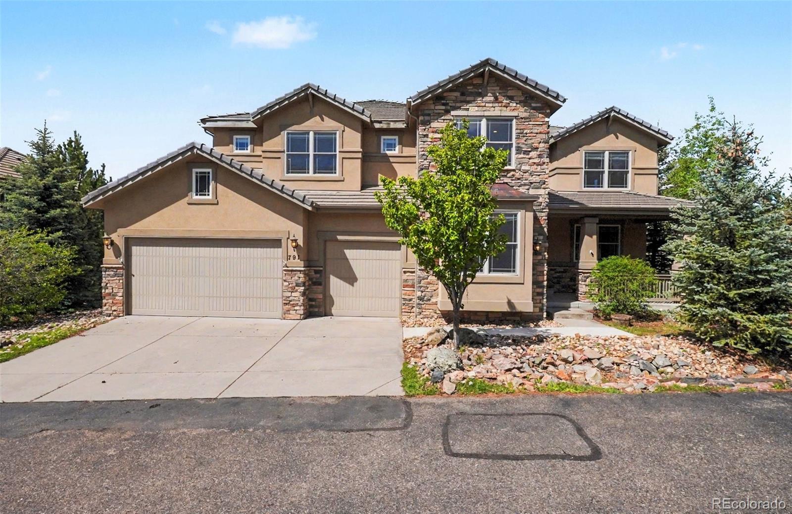 791 Elk Rest Road Evergreen, CO 80439 - Photo 2 of 46 a front view of a house with a yard and garage