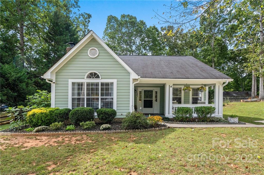 7192 Brookridge Drive Denver, NC 28037 - Photo 1 of 30 a view of a house with a yard plants and a lawn chairs under an umbrella