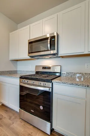 a kitchen with granite countertop a stove microwave and sink