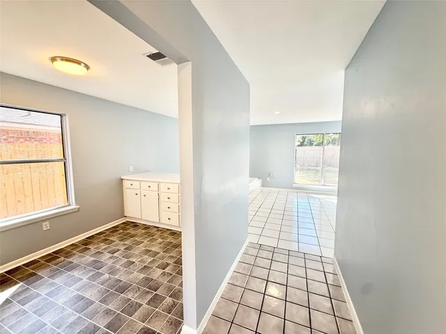 a spacious bedroom with a bed and a table lamp