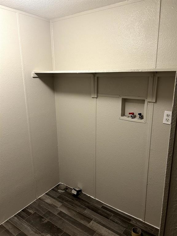 717 Byron Road Wilmer, TX 75172 - Photo 11 of 20 Dedicated utility space featuring durable wood-look flooring, light-toned wall paneling, and a built-in storage shelf