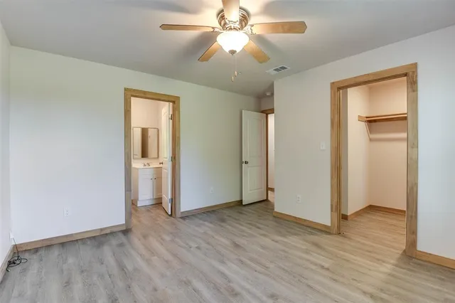 a view of a room with wooden floor and a ceiling fan