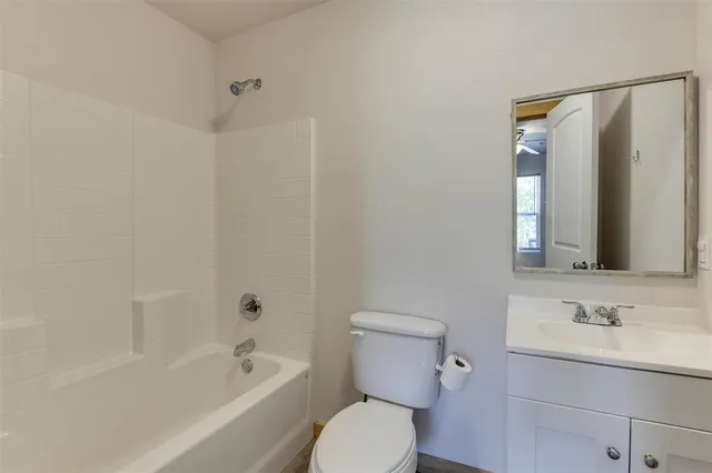 a bathroom with a toilet a sink a mirror a bathtub and vanity