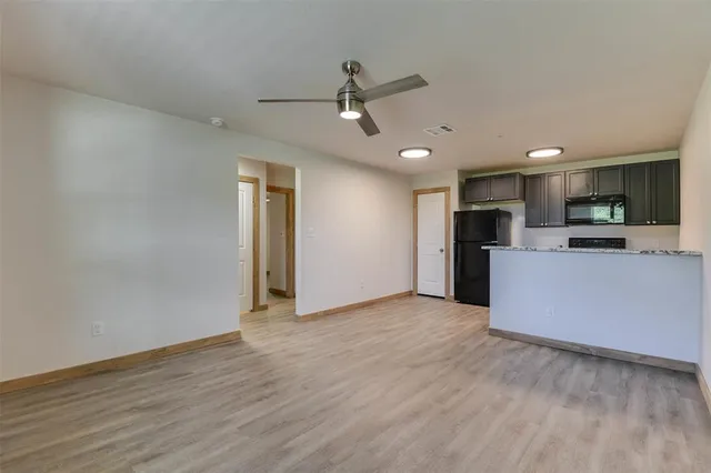 a view of kitchen with stainless steel appliances refrigerator stove microwave and cabinets