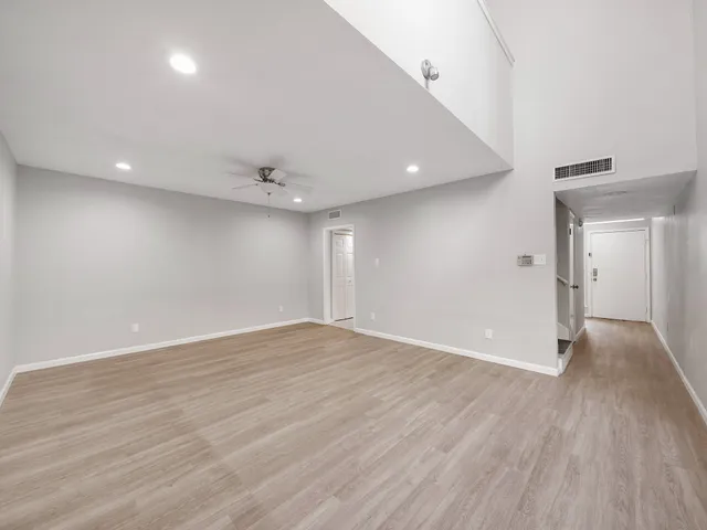 a view of an empty room with wooden floor