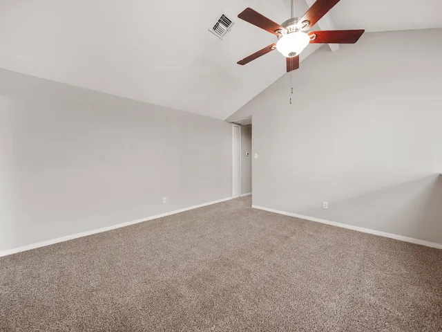 an empty room with a window and ceiling fan