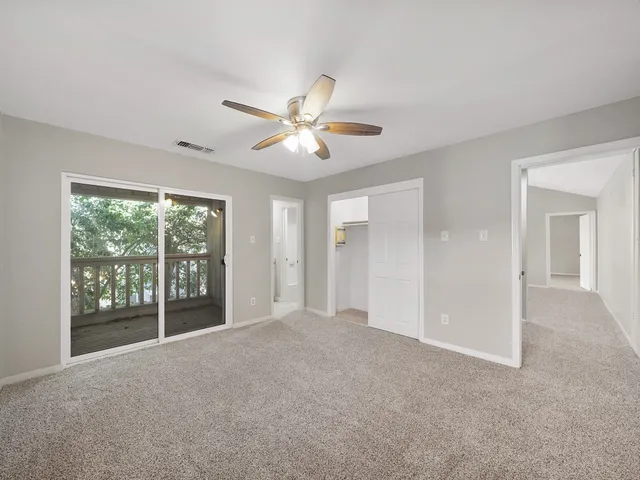 a view of a room with a ceiling fan and a large window