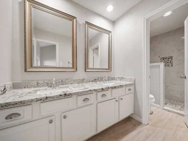 a bathroom with a granite countertop sink and a mirror