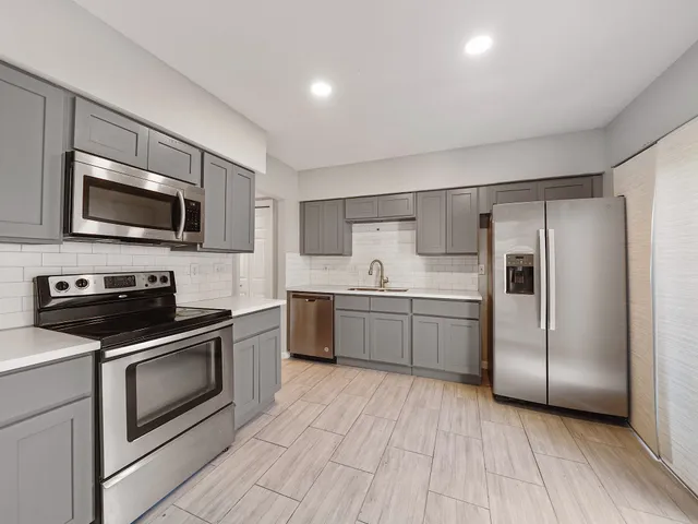 a kitchen with a sink stainless steel appliances and cabinets