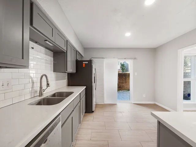 a kitchen with a sink a stove and cabinets