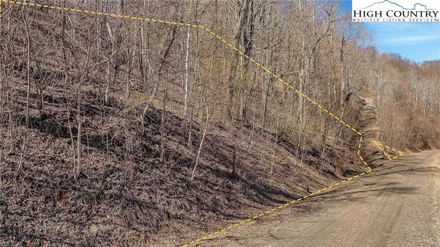 a view of a dry field with mountains in the background
