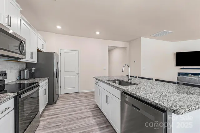 a kitchen with granite countertop stainless steel appliances and wooden cabinets
