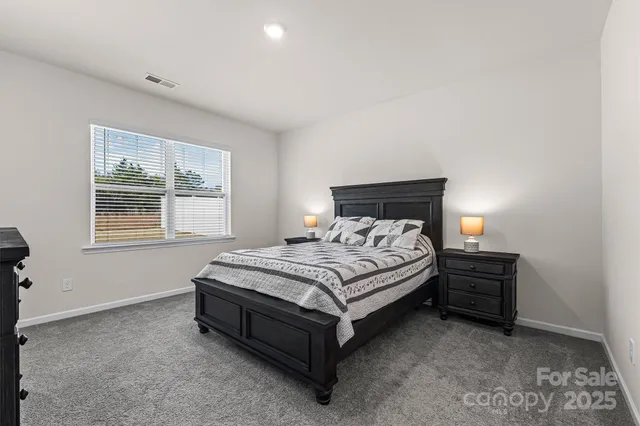 a bed sitting in a bedroom next to a window