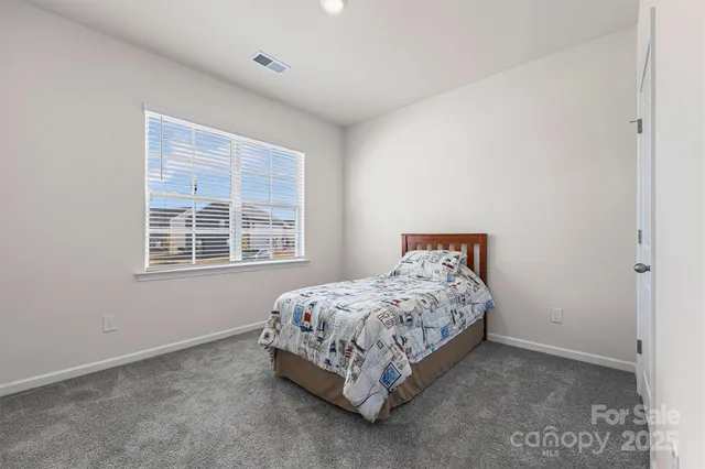 a bed sitting in a bedroom next to a window