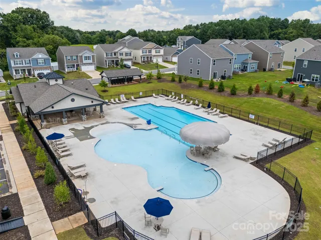 a view of a house with pool and chairs