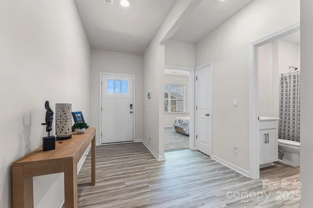 a view of a hallway with bathroom and wooden floor