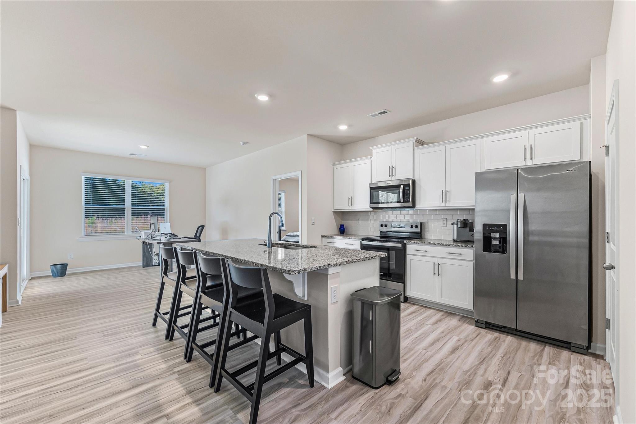 1219 Rutherford Street York, SC 29745 - Photo 10 of 38 a kitchen with stainless steel appliances a dining table chairs stove refrigerator and microwave
