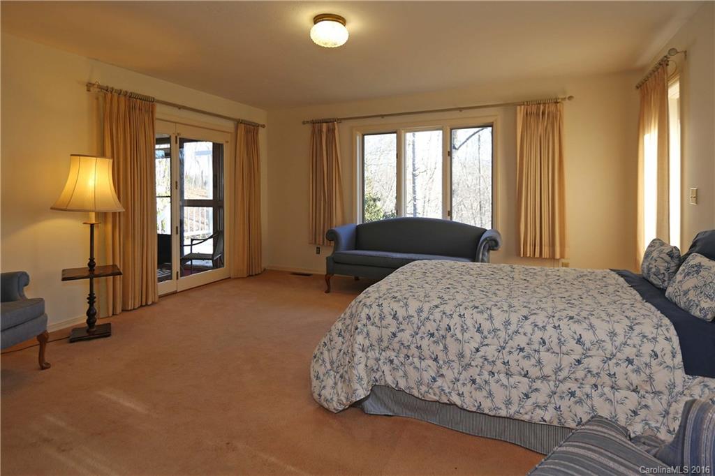 435 Clemson Road Waynesville, NC 28786 - Photo 11 of 21 a bedroom with a bed and a lamp