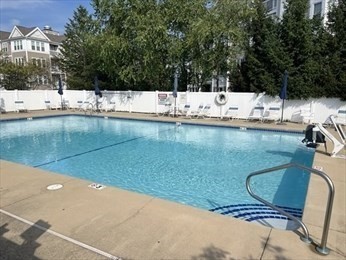107 Clocktower Drive, Unit 207 Waltham, MA 02452 - Photo 17 of 18 a view of a swimming pool with a lounge chair