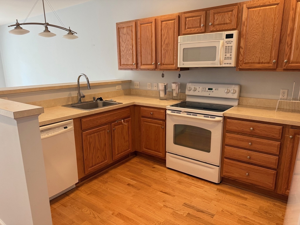 107 Clocktower Drive, Unit 207 Waltham, MA 02452 - Photo 4 of 18 a kitchen with a sink stove and cabinets