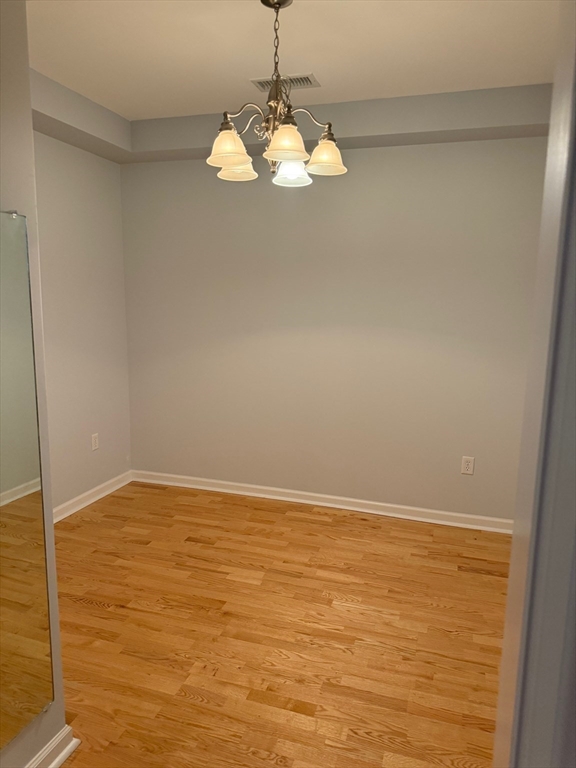 107 Clocktower Drive, Unit 207 Waltham, MA 02452 - Photo 8 of 18 a view of wooden floor and chandelier in a room