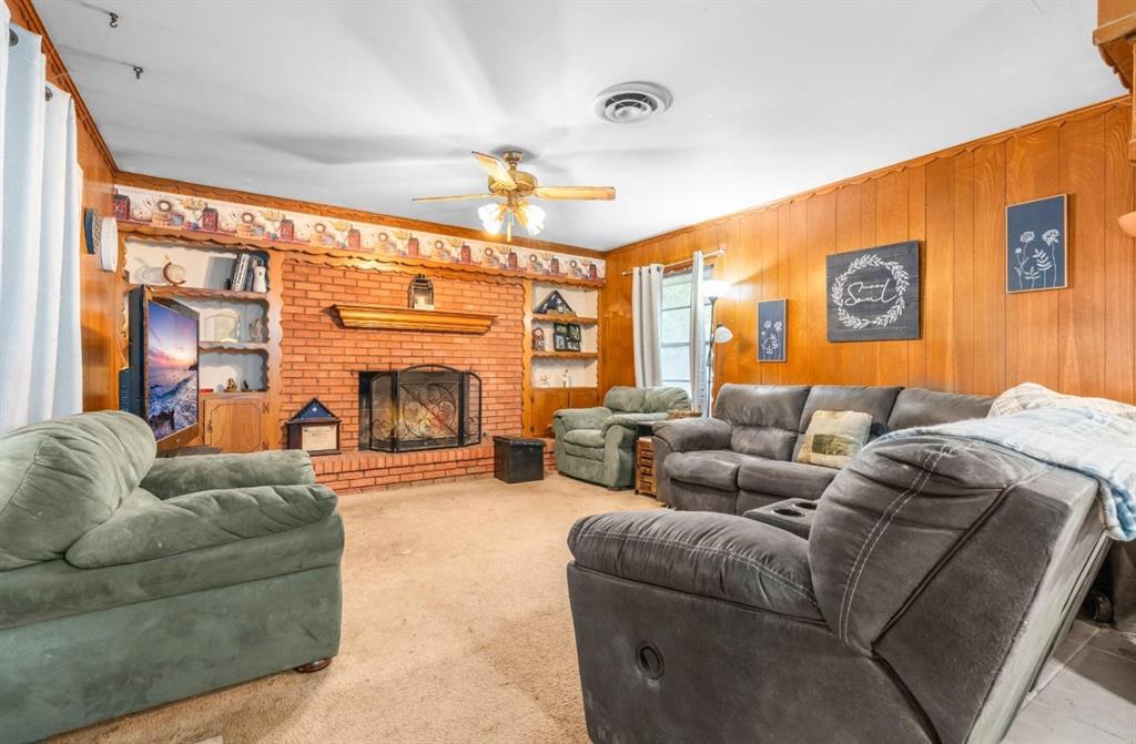 609 South Files Street Itasca, TX 76055 - Photo 13 of 29 a living room with furniture a fireplace and a flat screen tv