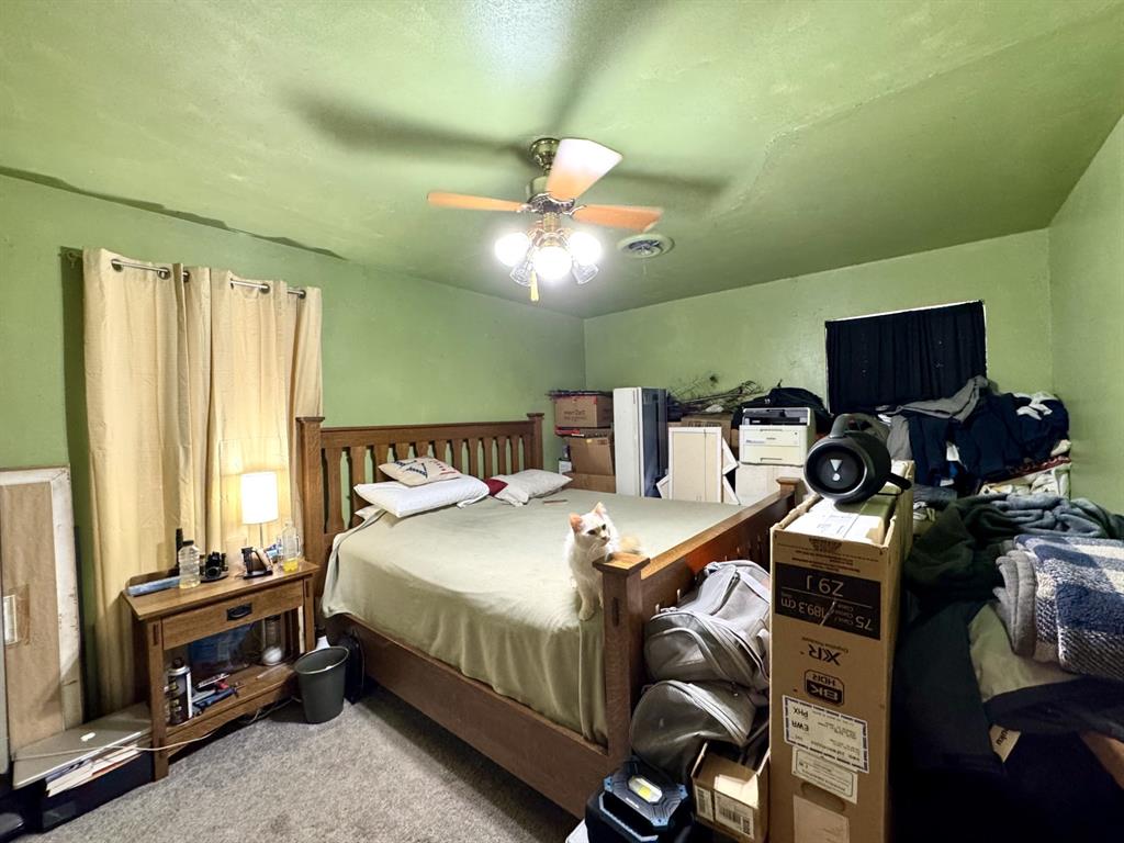 609 South Files Street Itasca, TX 76055 - Photo 16 of 29 a bedroom with a bed and a chandelier