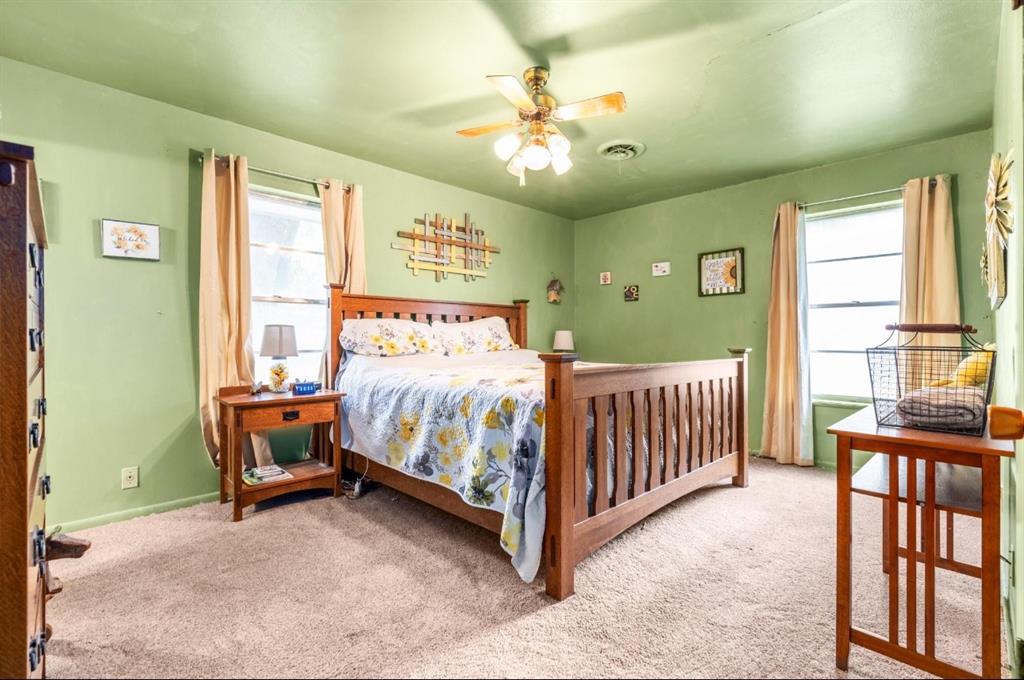 609 South Files Street Itasca, TX 76055 - Photo 17 of 29 a bedroom with a bed and a chandelier