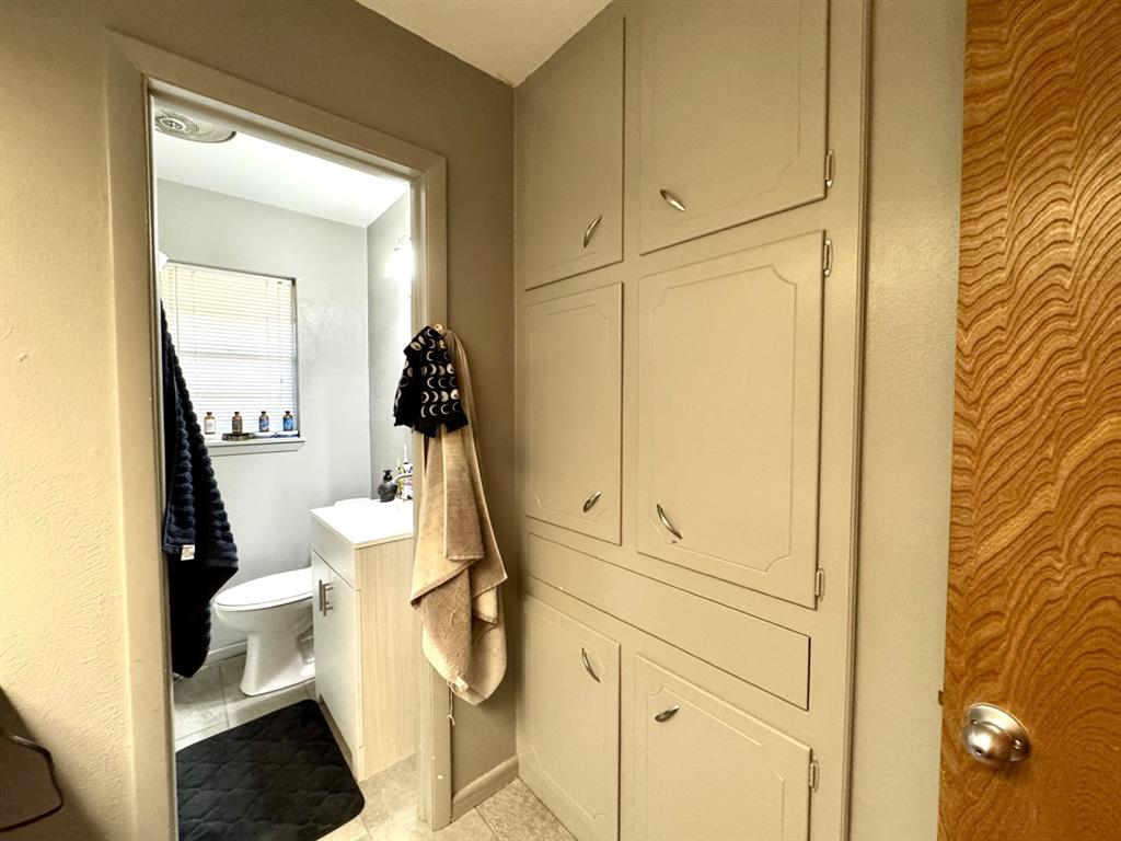 609 South Files Street Itasca, TX 76055 - Photo 23 of 29 a bathroom with a sink and mirror with toilet