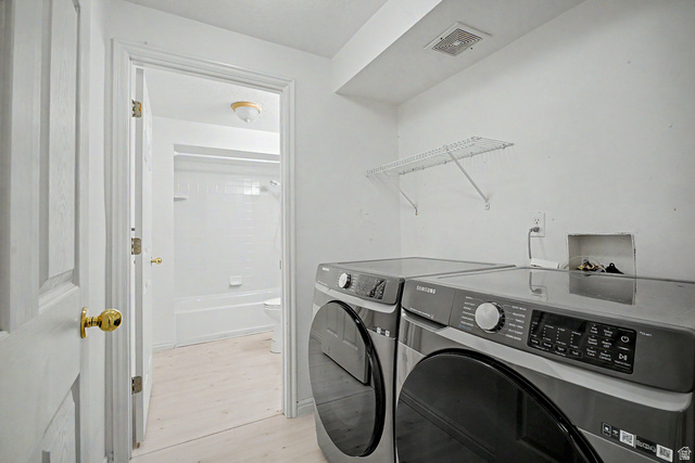 2058 California Avenue, Unit 2 Provo, UT 84606 - Photo 12 of 32 Dedicated laundry area featuring front-loading machines, overhead wire shelving, and light-toned flooring