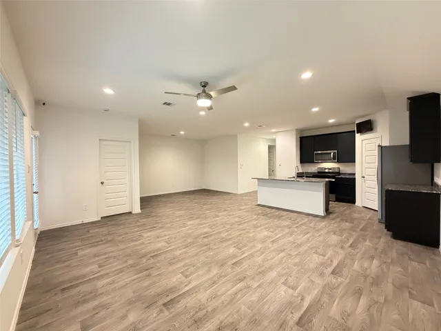 a kitchen with stainless steel appliances kitchen island granite countertop a stove and a refrigerator