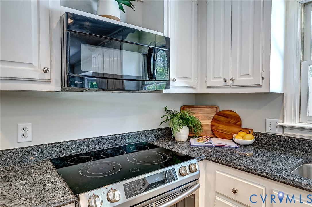 5201 Stone Horse Road Glen Allen, VA 23059 - Photo 17 of 54 a kitchen with granite countertop a stove top oven microwave and cabinets