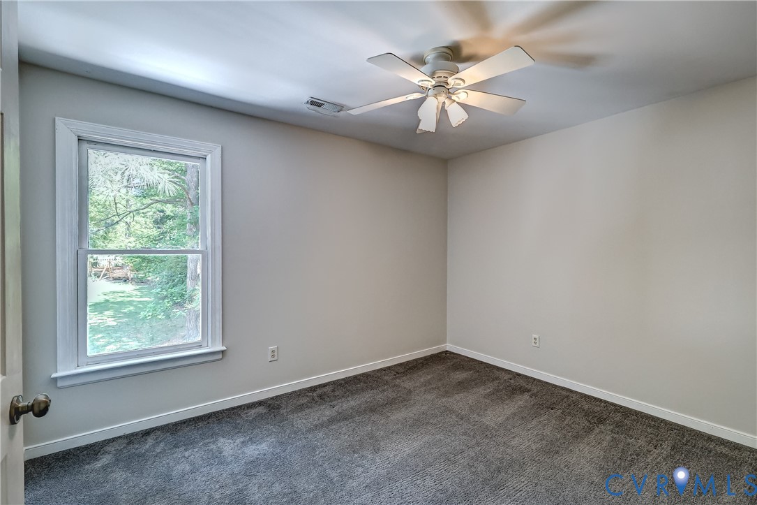 5201 Stone Horse Road Glen Allen, VA 23059 - Photo 36 of 54 an empty room with a chandelier fan and windows