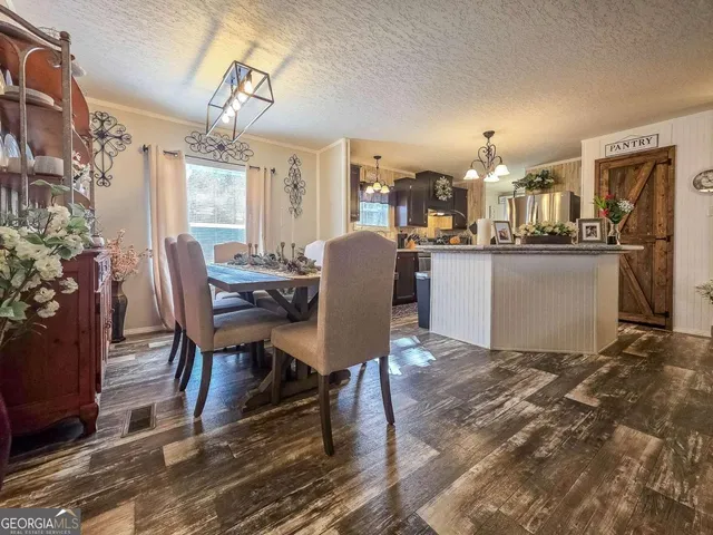 a dining room with wooden floor and chandelier
