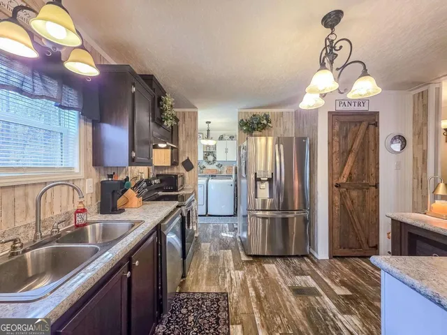 a kitchen with sink a refrigerator and microwave